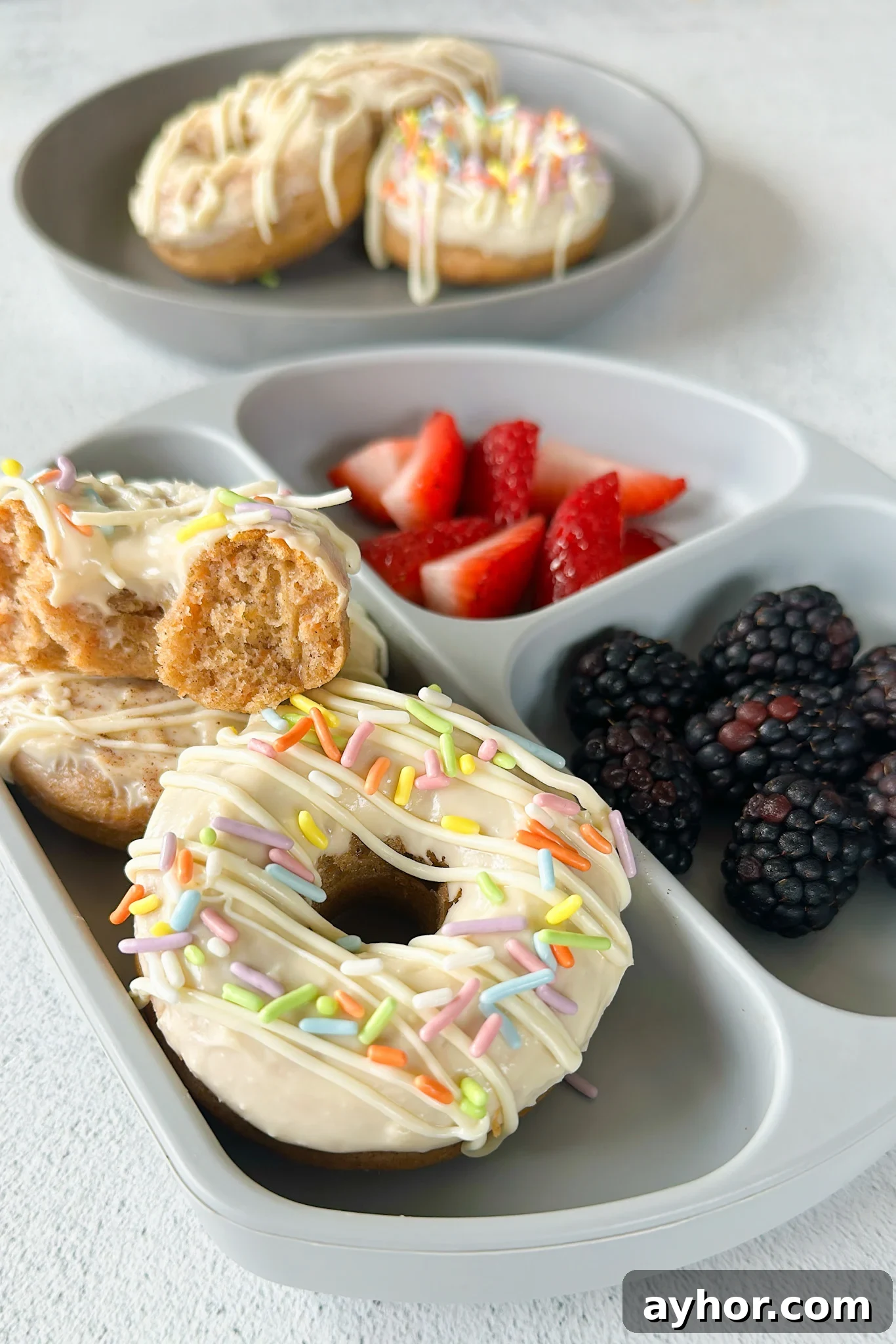 Moist Baked Carrot Cake Donuts with Cream Cheese Glaze 2 Baked carrot cake donuts served with berries.