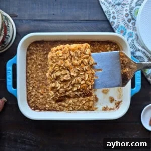 Creamy Sweet Potato Oatmeal Recipe for Breakfast and Meal Prep 3 Spatula lifting out slice of sweet potato baked oatmeal from blue staub baking dish.