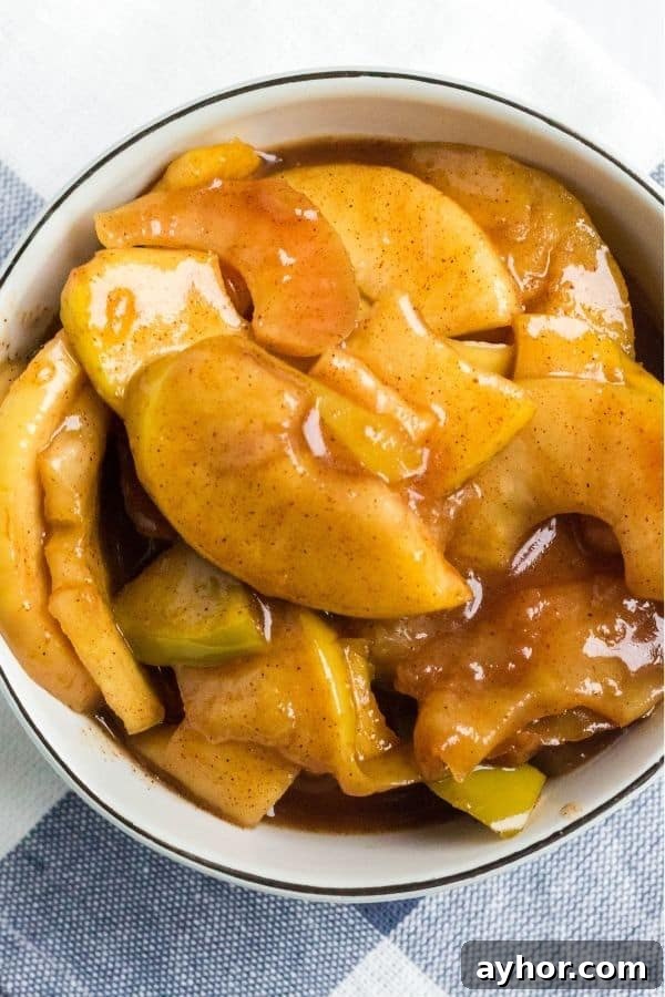 Instant Pot Cinnamon Apples: Quick Spiced Apple Dessert 4 A serving of tender pressure cooker cinnamon apples in a cream-colored bowl.