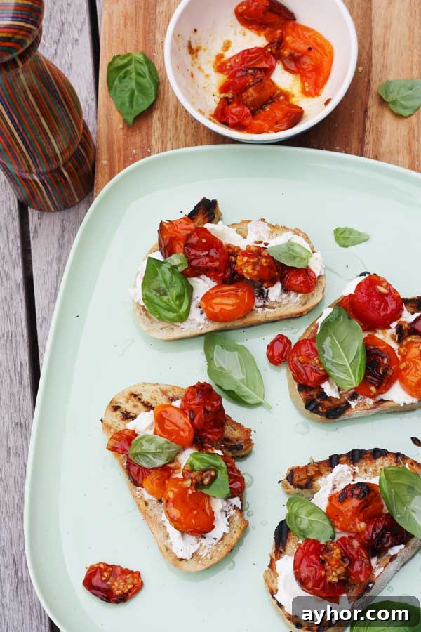 Overhead of a white plate with tomato and ricotta bruschetta on it.