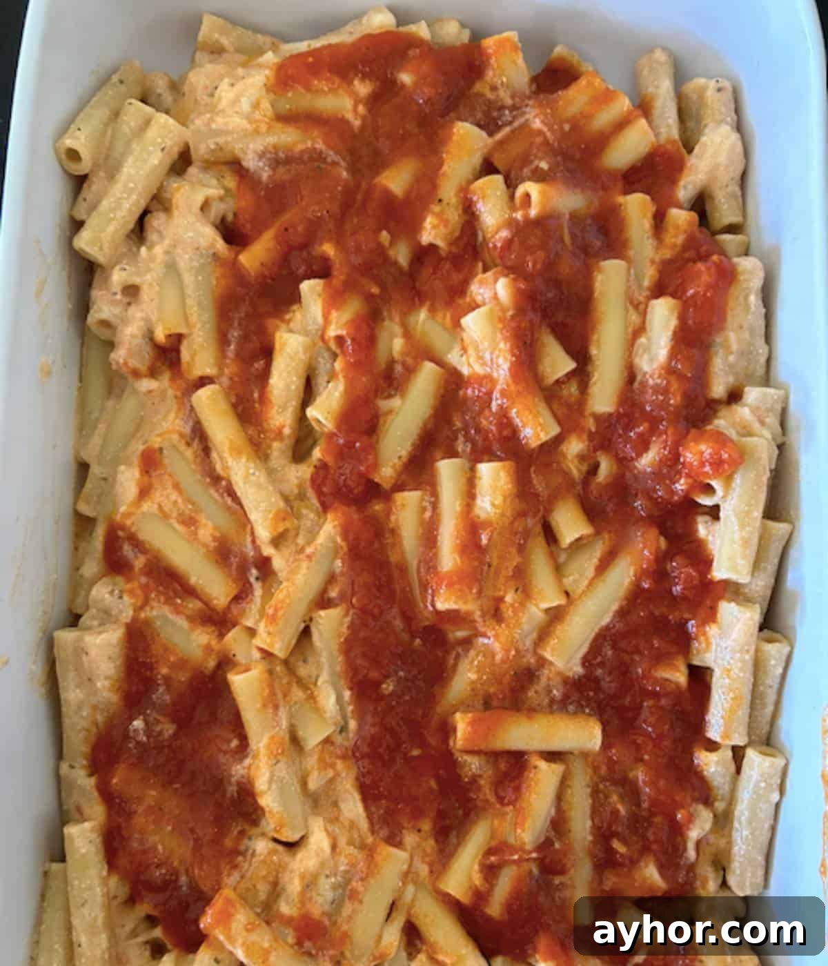 Vegetarian Baked Ziti with Cheesy Tomato Sauce 8 Baked ziti in casserole dish topped with sauce.