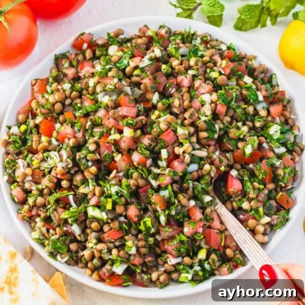 lentil tabbouleh with silver spoon and hand