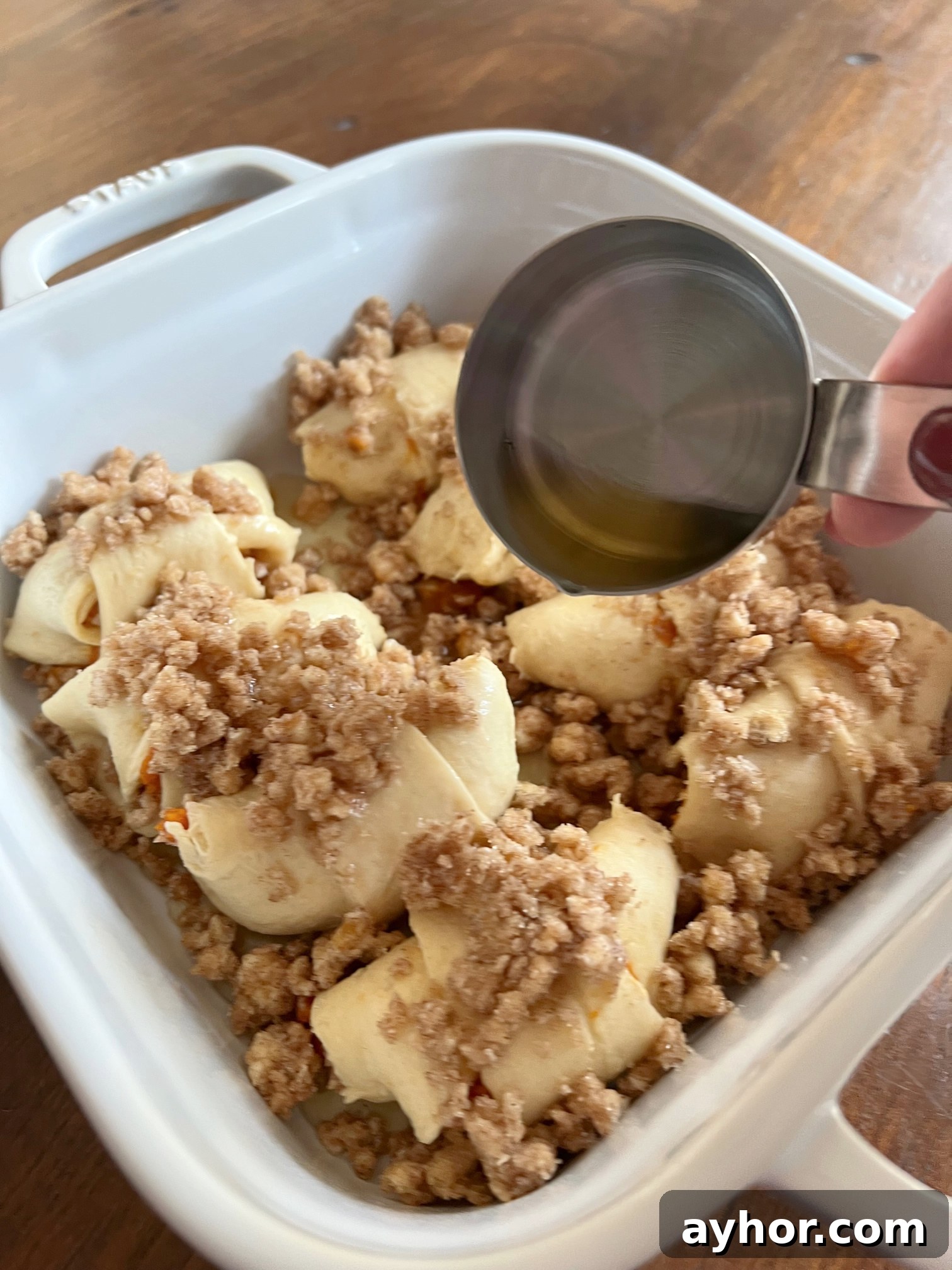 This is a photo showing apple juice poured over the dumplings. The last step before placing them in the oven. 