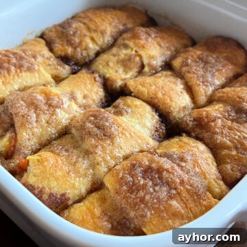 Photo of Pumpkin Crescent Roll Dumplings baked in a white square baking dish.