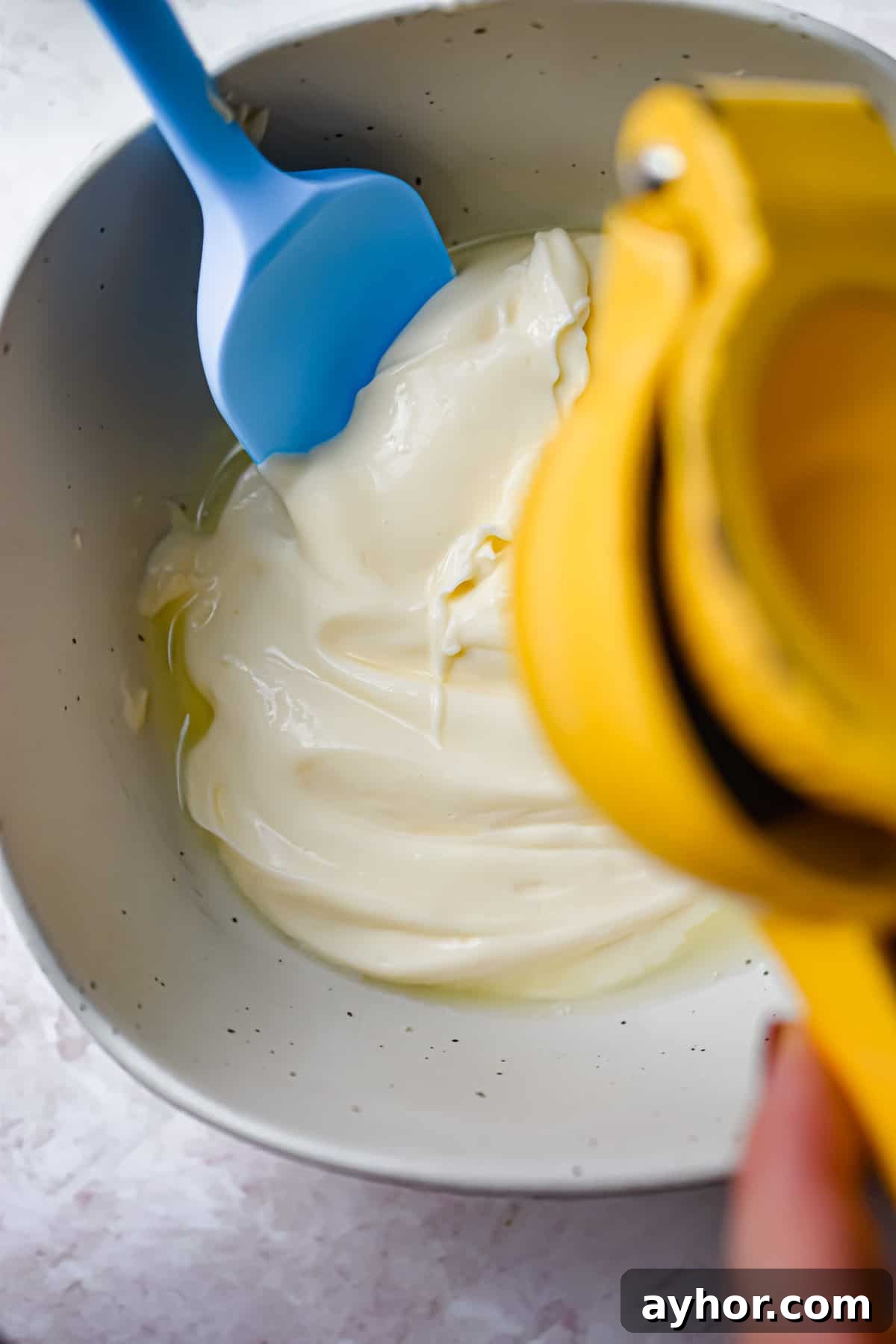 A juicer is squeezing lime juice into the bowl