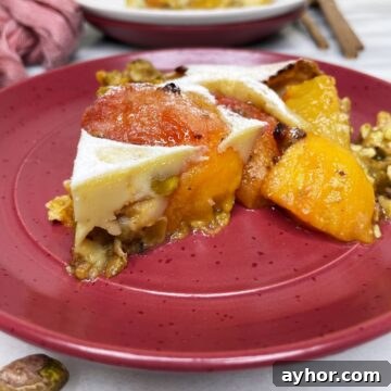 Peach clafoutis slice on a red dessert plate.