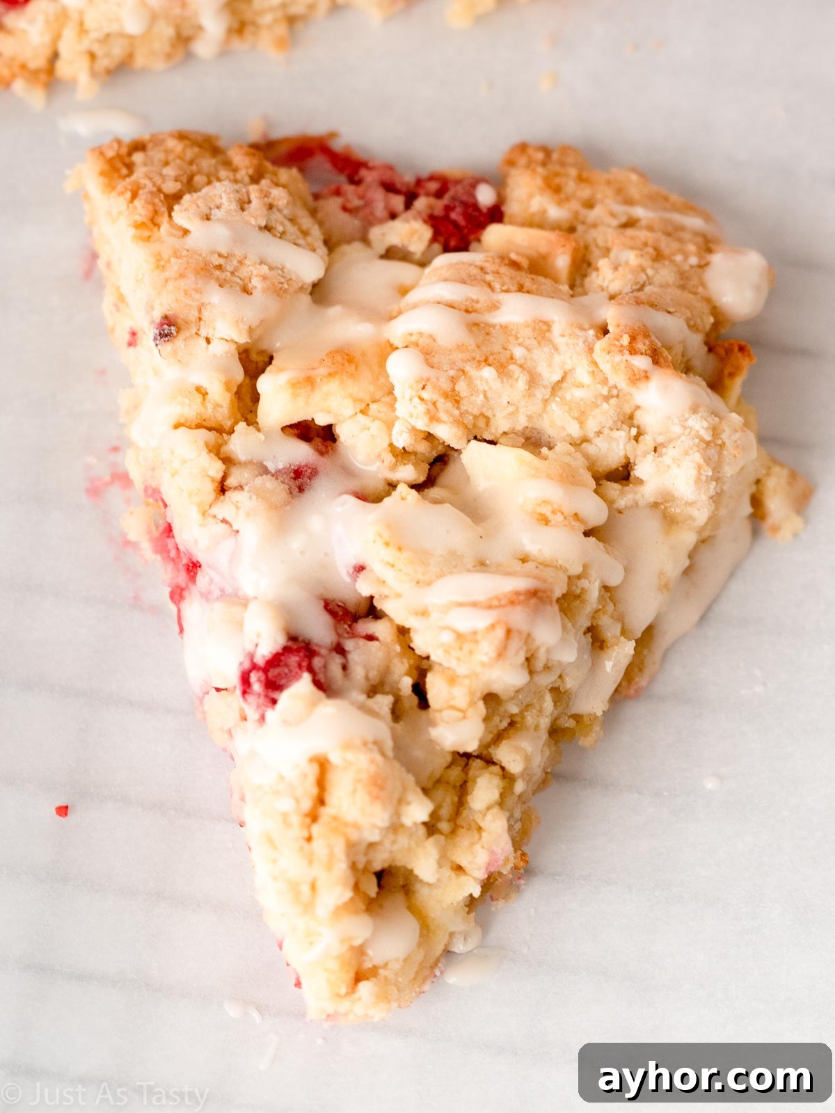 White Chocolate Raspberry Scones Recipe - Tender Morning Treat 4 Close-up of a glazed white chocolate raspberry scone.