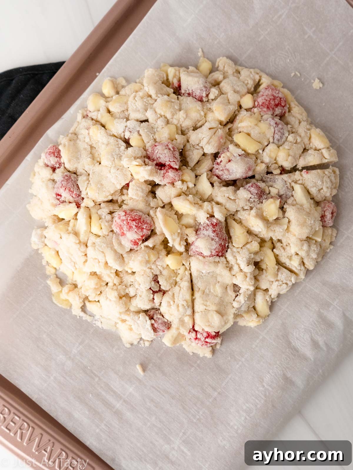 White Chocolate Raspberry Scones Recipe - Tender Morning Treat 9 White chocolate raspberry scone dough shaped into a disc on baking sheet.