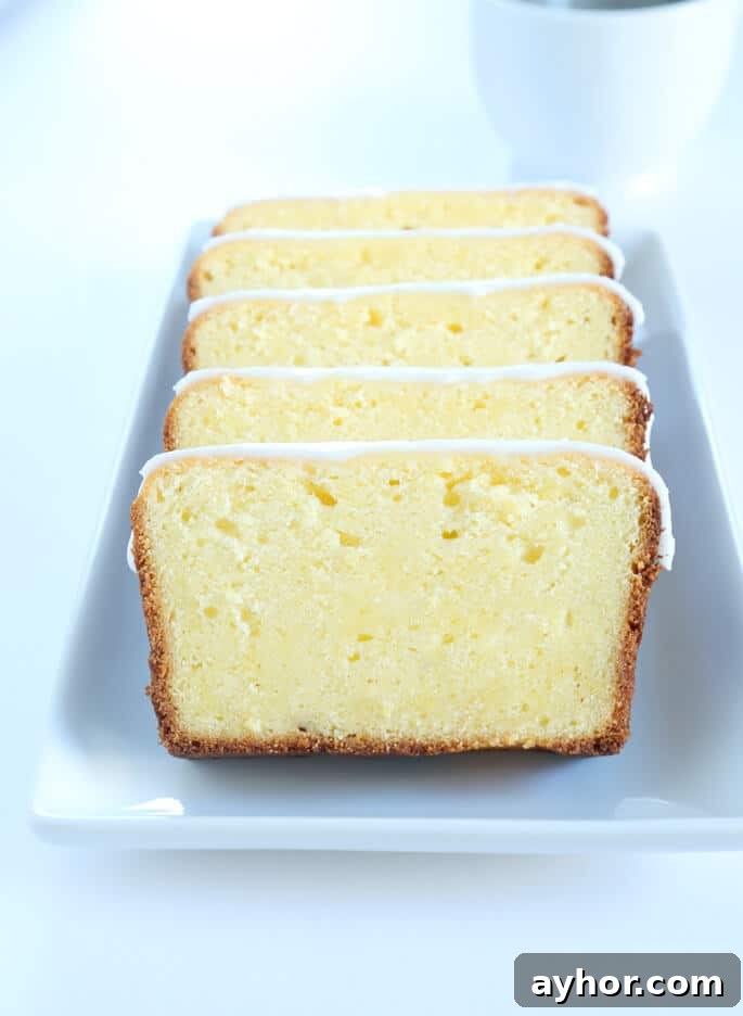 Glazed Gluten-Free Lemon Pound Cake Recipe 5 Slices of lemon pound cake on a rectangular serving platter.