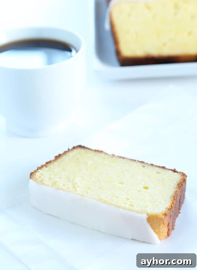 Glazed Gluten-Free Lemon Pound Cake Recipe 8 One slice of lemon pound cake on a small plate, with coffee.