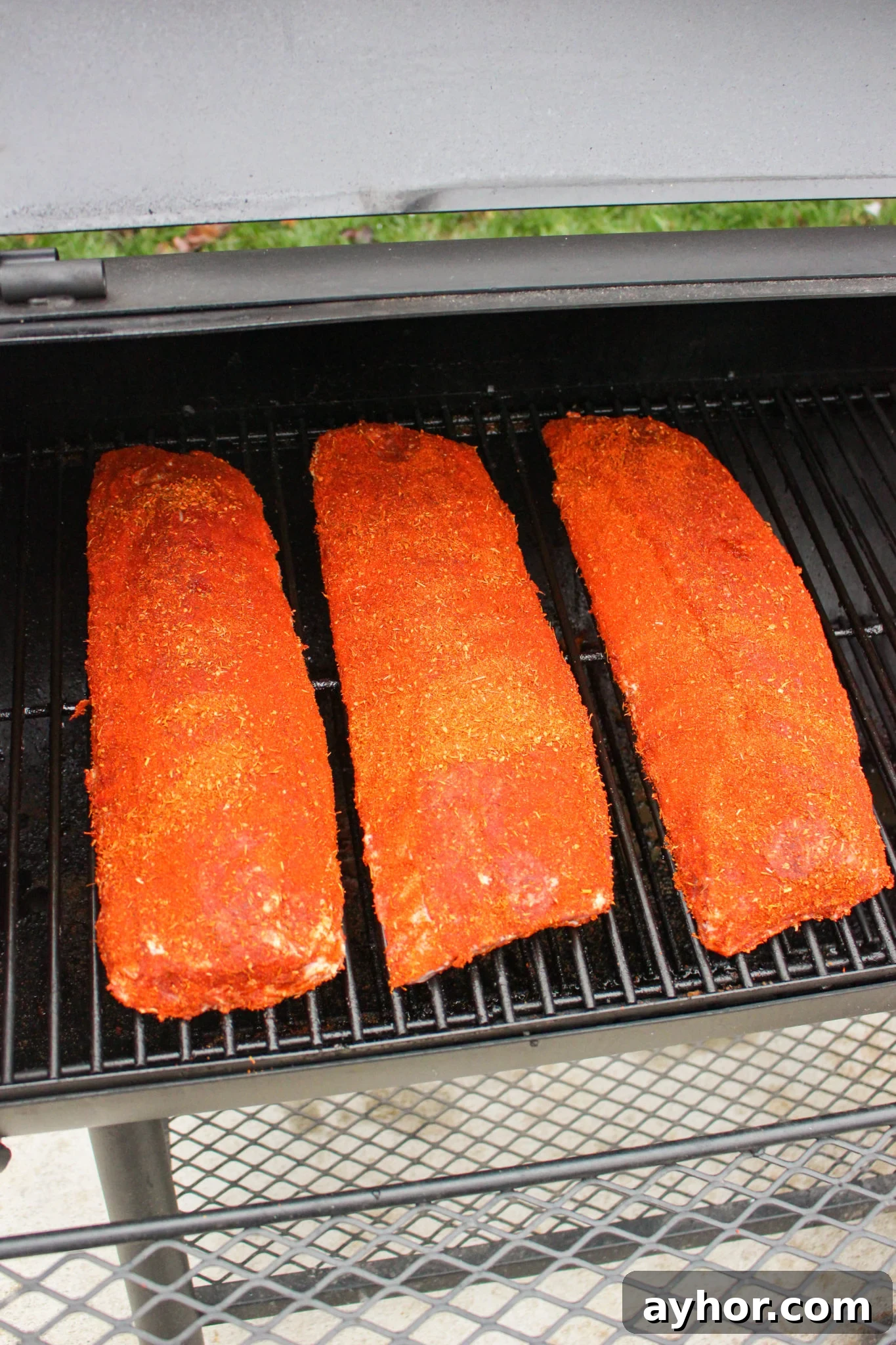Maple-Cajun Smoked Ribs Recipe for Tender, Flavorful BBQ 2 Ribs getting placed on the smoker.