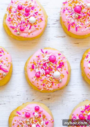 Sand Dollar Cookie Recipe: Crisp Shortbread Cookies Shaped Like Sand Dollars 13 Pink frosted cookies with colorful sprinkles arranged on a white surface.