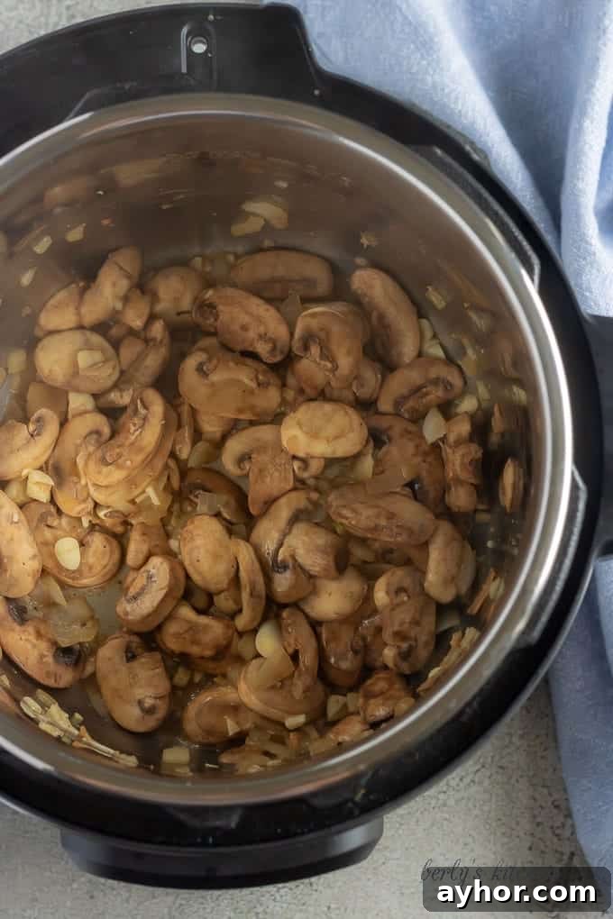 Instant Pot Pork Chops in Creamy Mushroom Gravy 5 Another top-down picture of the mushrooms, onions, and garlic, cooking inside the Instant Pot.
