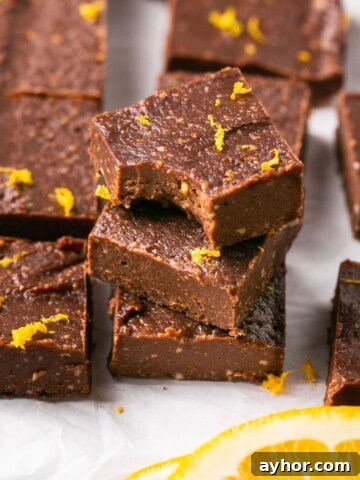 A stack of three pieces of vegan orange chocolate fudge.