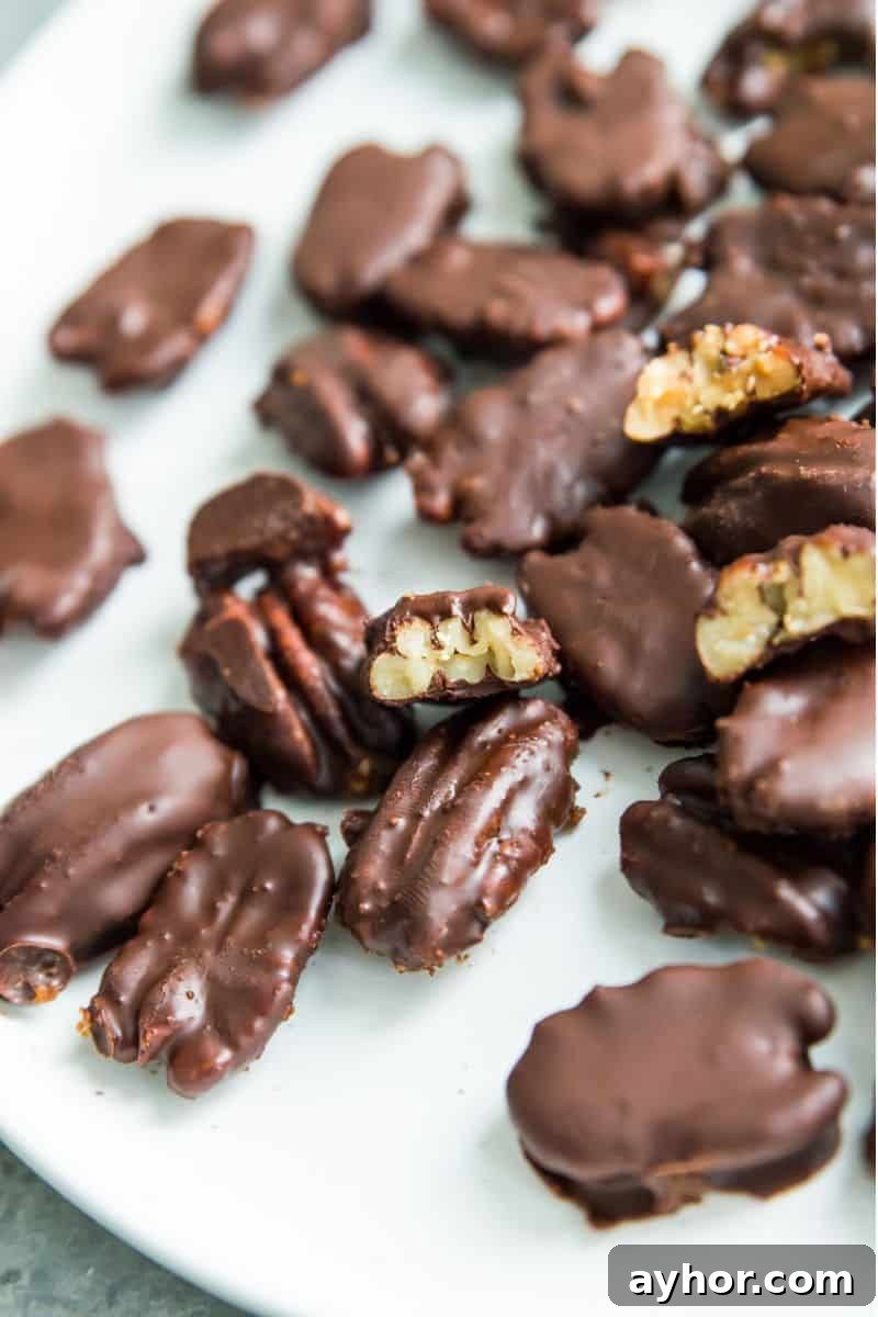 Homemade Chocolate-Covered Pecans: Simple No-Bake Recipe 8 A plate with chocolate covered pecans on it and one pecan has a bite out of it.