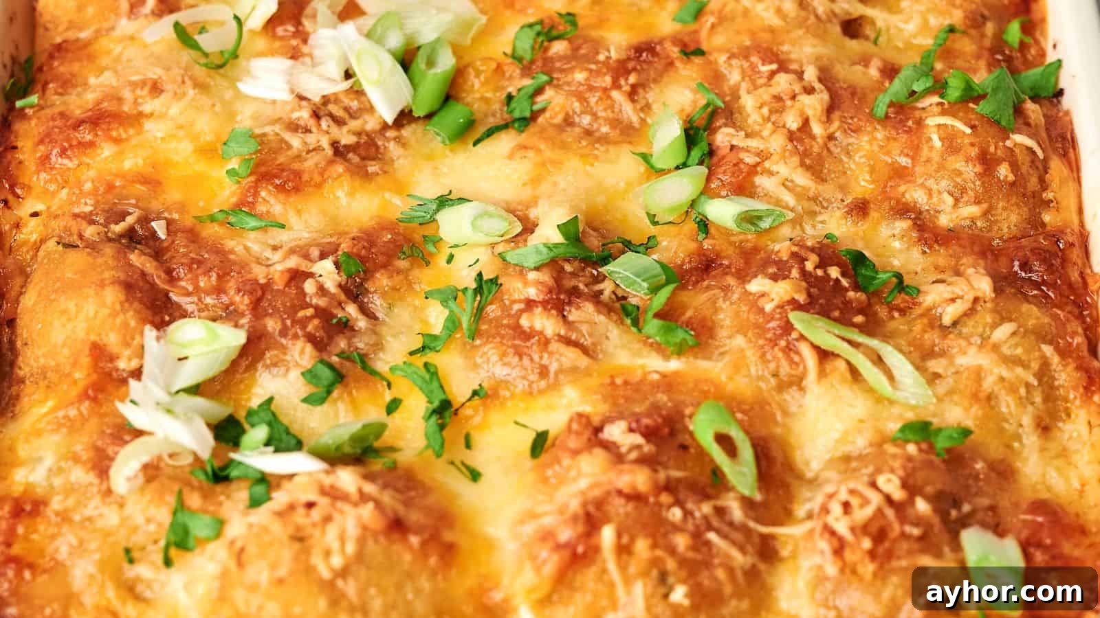 29 Breakfast Recipes to Make Your Mornings Feel Romantic 14 Close-up of a tater tot breakfast casserole topped with melted cheese, sliced green onions, and chopped herbs.