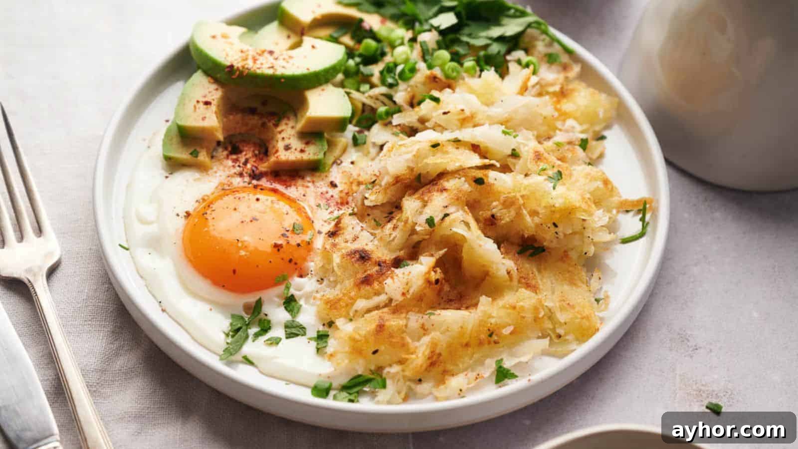 29 Breakfast Recipes to Make Your Mornings Feel Romantic 24 Hash Browns on a white plate with an egg and avocado.