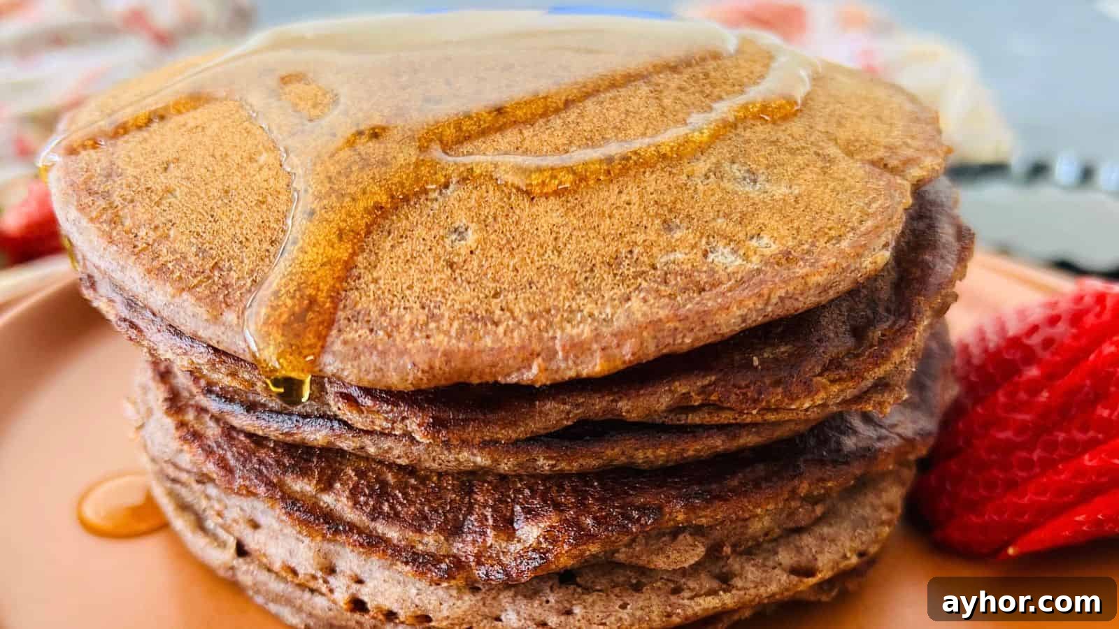 29 Breakfast Recipes to Make Your Mornings Feel Romantic 30 Stack of Ragi pancakes with syrup drizzled on top, accompanied by strawberries on the side.