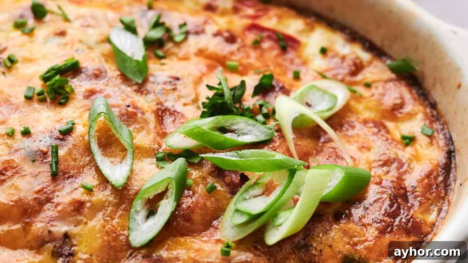 29 Breakfast Recipes to Make Your Mornings Feel Romantic 8 Breakfast casserole topped with melted cheese, garnished with sliced green onions and chopped herbs.