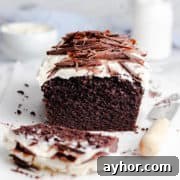 Guinness chocolate loaf cake topped with frosting and chocolate curls