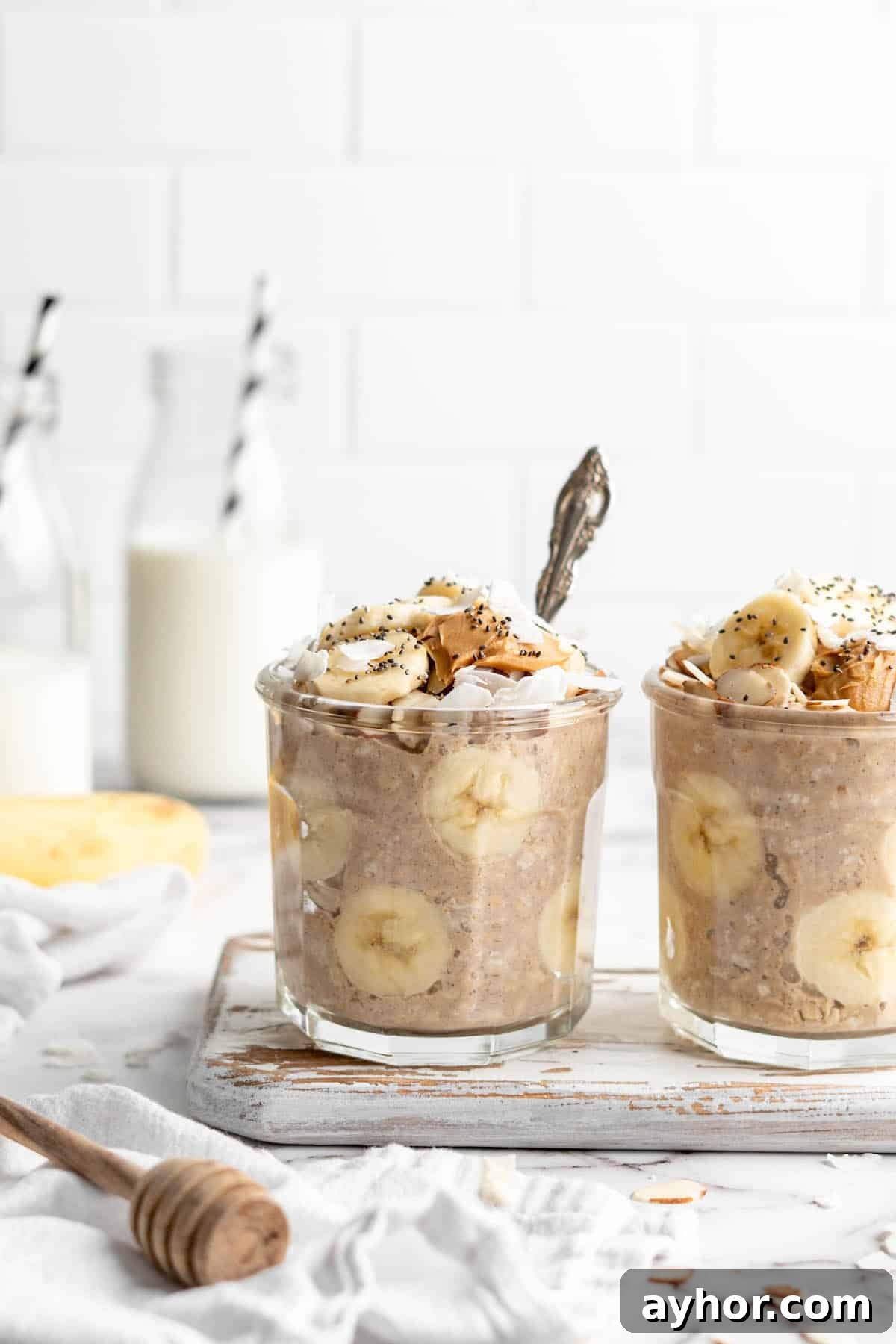 Two jars of overnight oats with bananas and peanut butter