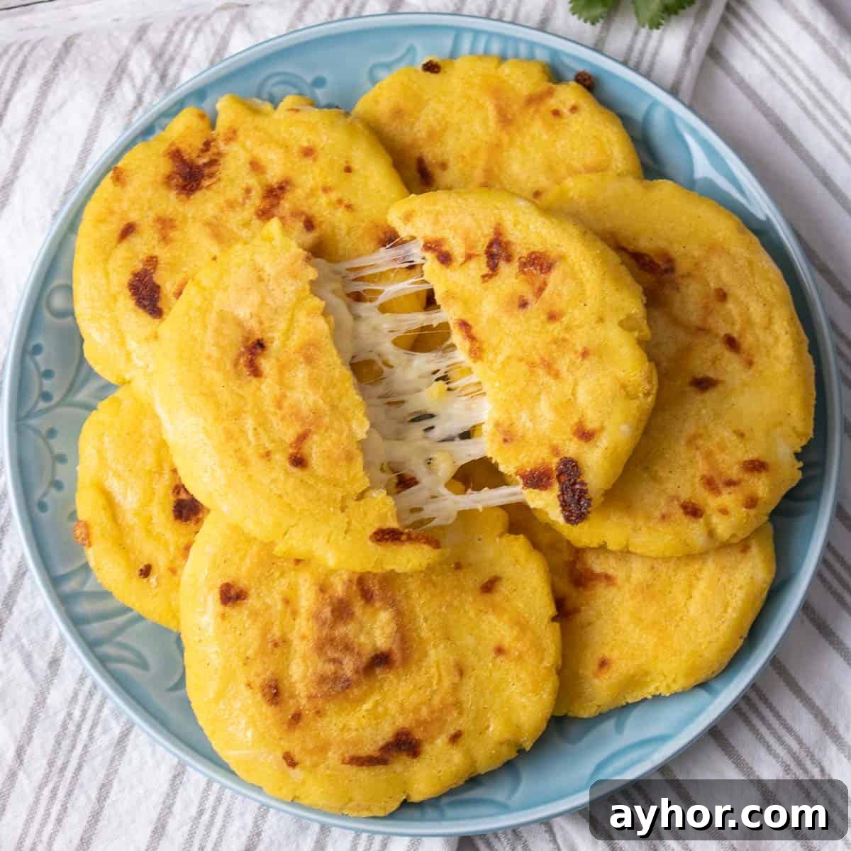 cheese pull arepa on top of cooked arepas.