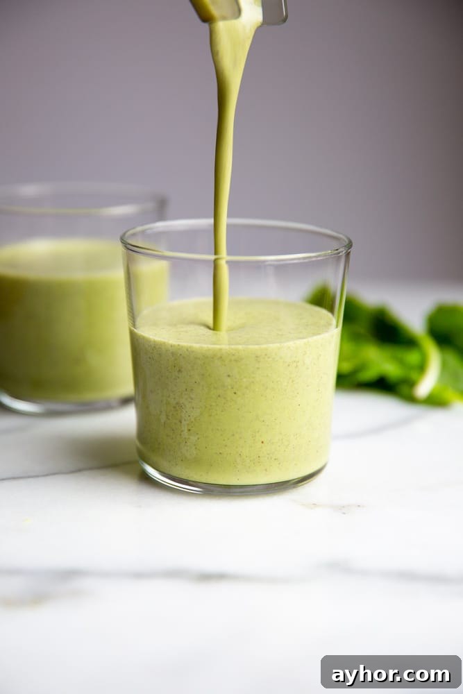 Low-Sugar Green Smoothie Recipe That Actually Tastes Great 2 Close up of the green smoothie being poured into a glass.