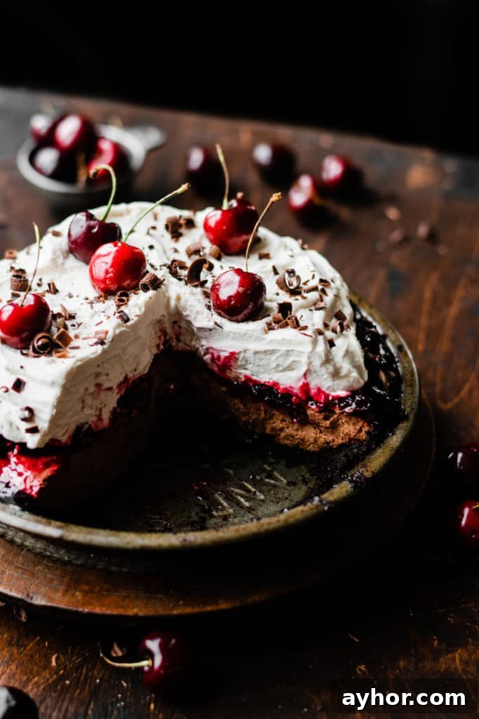 No-Bake Black Forest Chocolate Cherry Pie Recipe 3 No Bake Black Forest Pie on a vintage wooden surface, with a few slices cut out
