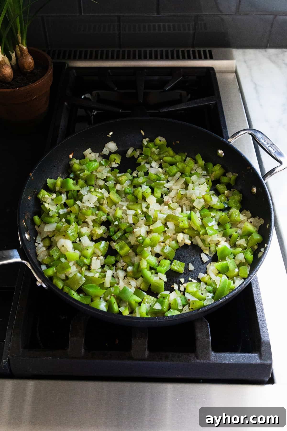 Cooked green peppers, onions, and jalapenos in a skillet.