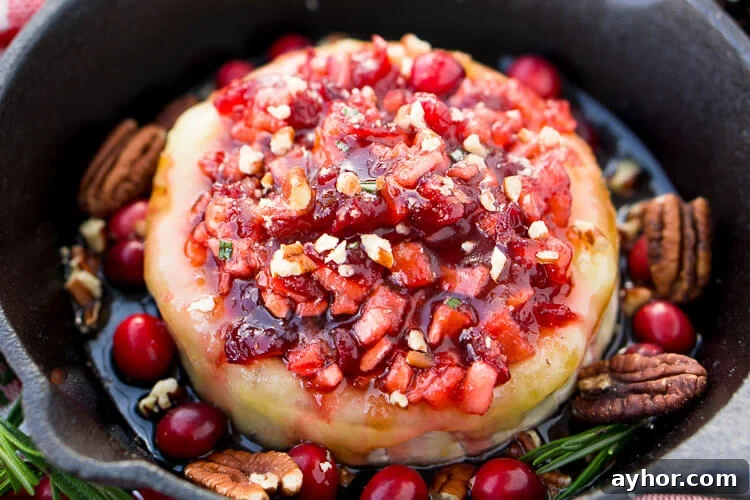 Apple Cranberry Baked Brie is a delicious cheese appetizer loaded with brown sugar, maple syrup, pecans, and an apple cranberry compote.