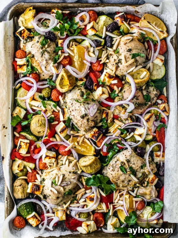 Overhead shot of sheet pan covered with roasted veggies, chicken, and feta.