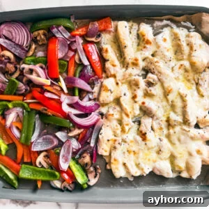 Sheet pan with veggies and cheesy chicken morsels.