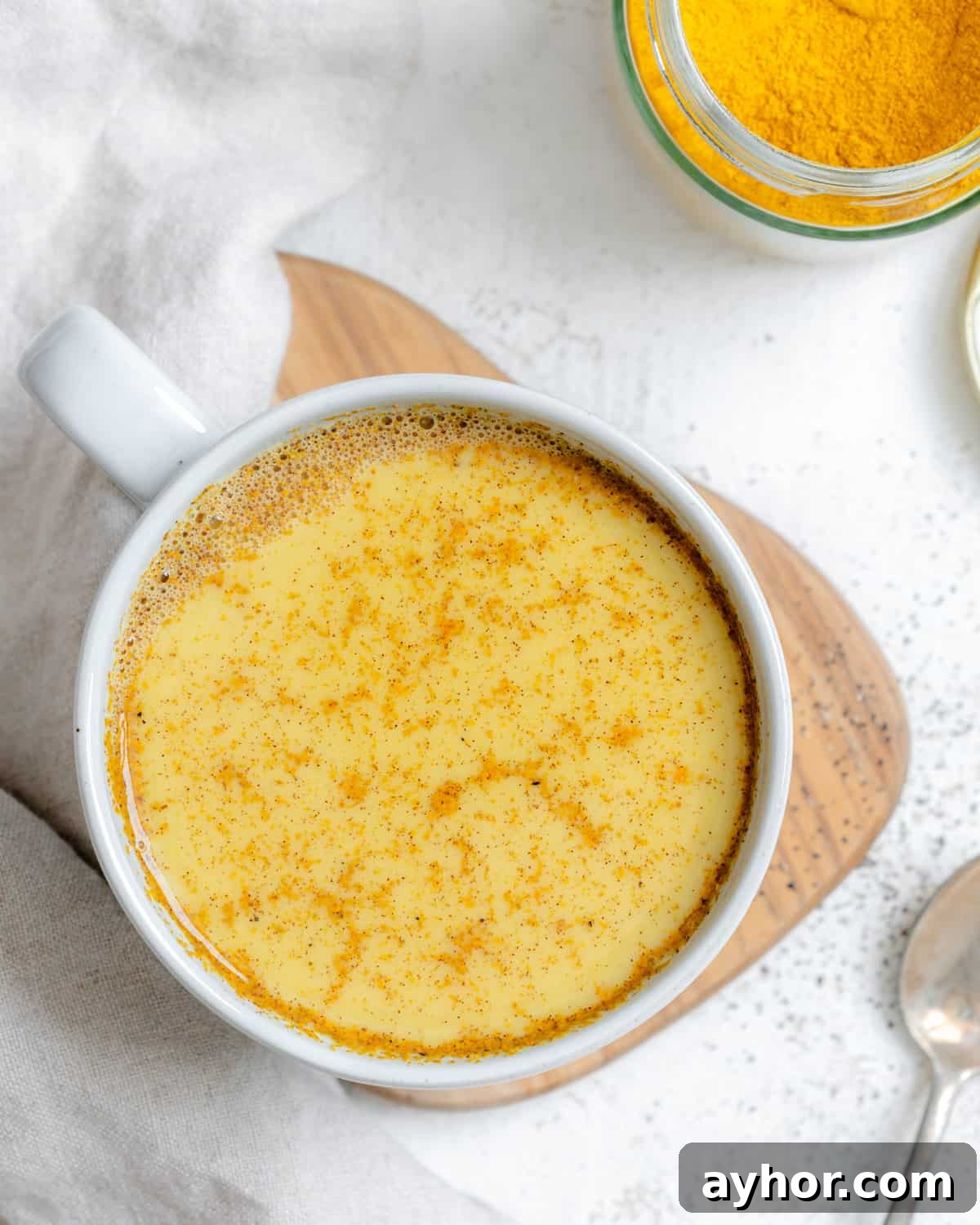 completed Turmeric Golden Milk [Haldi Doodh] in a white cup against a white background