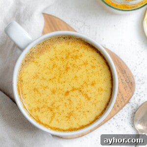 completed Turmeric Golden Milk [Haldi Doodh] in a white cup against a white background
