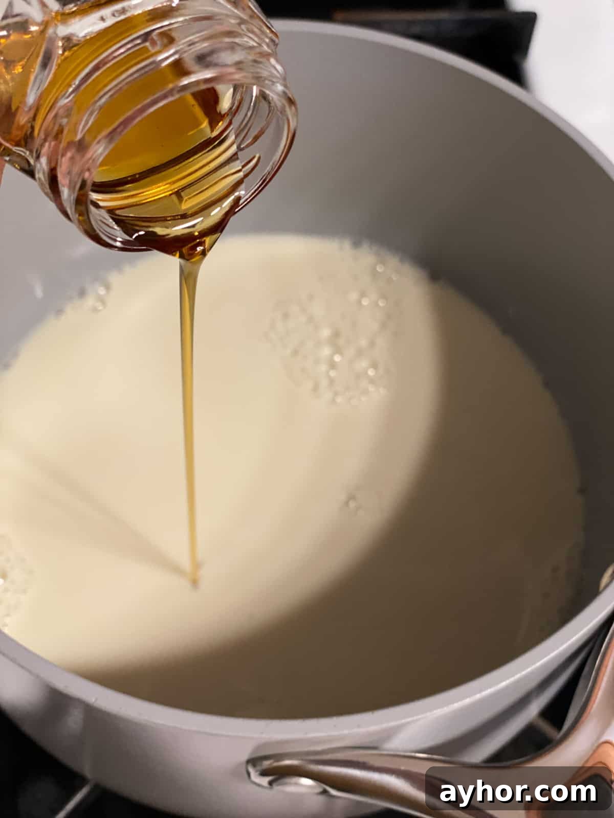 How to Make Turmeric Golden Milk: Creamy Anti-Inflammatory Latte 5 process shot of adding maple syrup to pot
