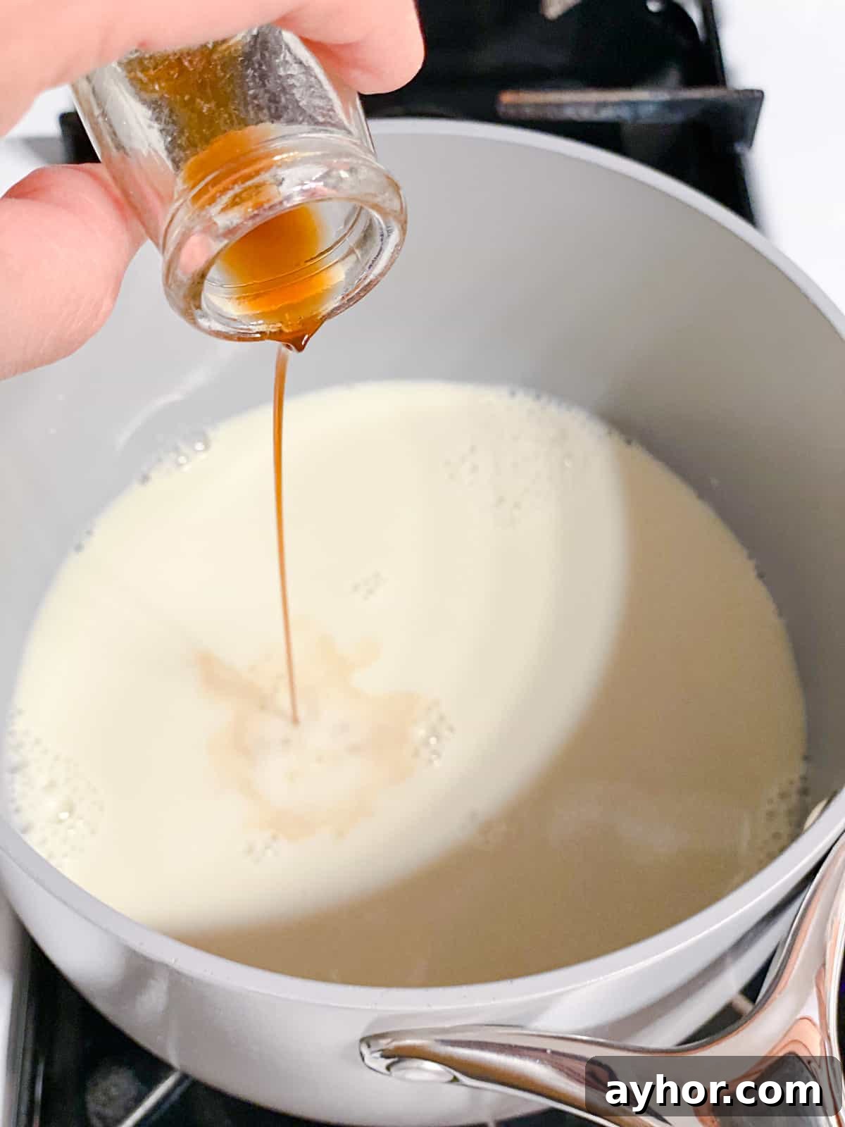 How to Make Turmeric Golden Milk: Creamy Anti-Inflammatory Latte 6 process shot of adding vanilla extract to pot