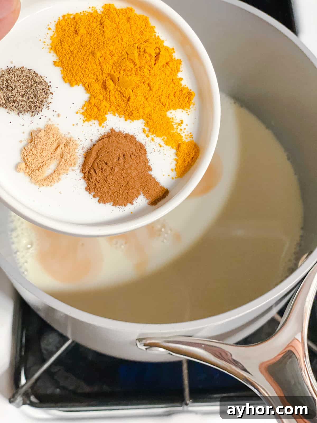 How to Make Turmeric Golden Milk: Creamy Anti-Inflammatory Latte 7 process shot of adding spices to pot