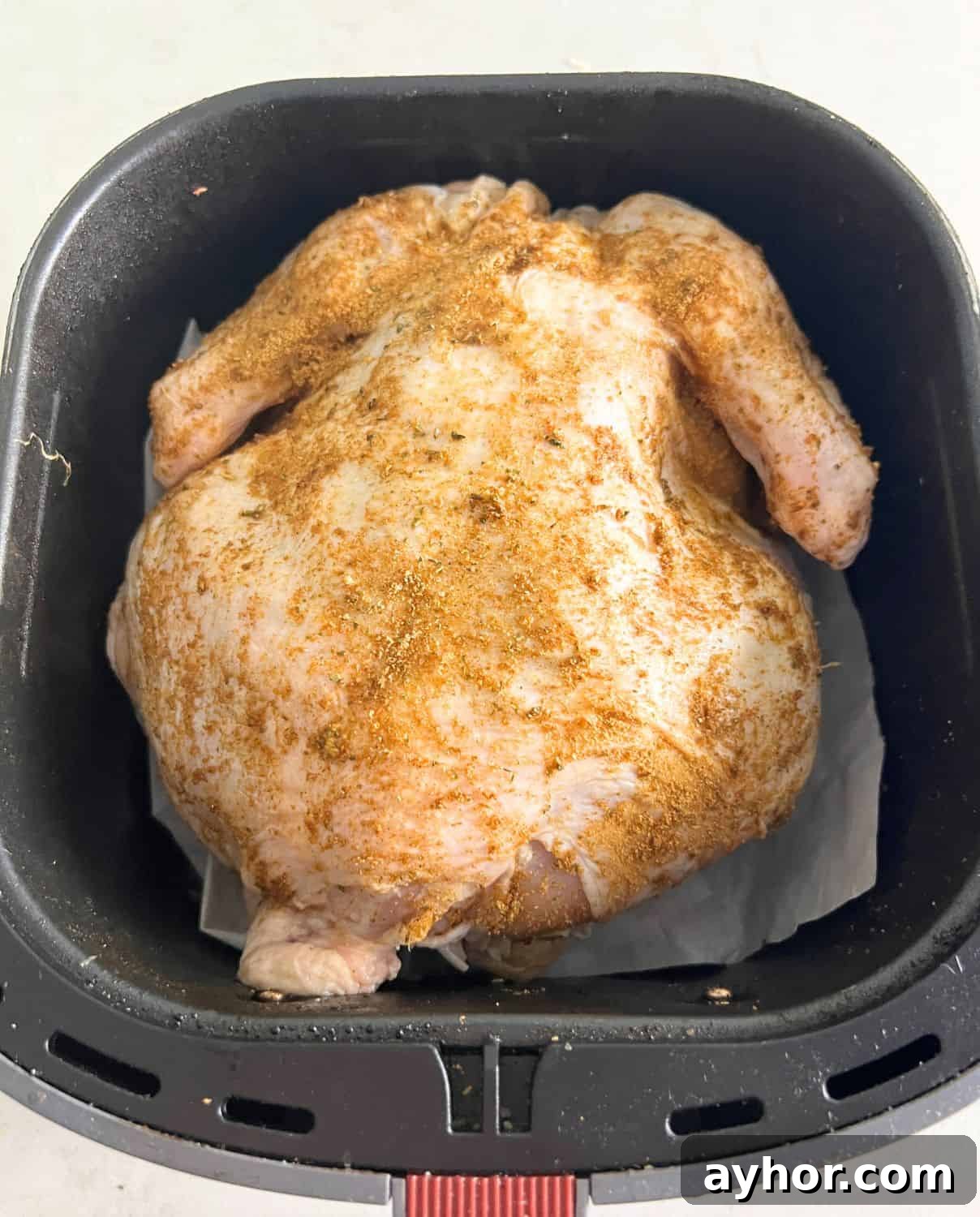 Crispy Whole Chicken in the Air Fryer: Step-by-Step Recipe 6 Seasoned whole chicken in air fryer basket.