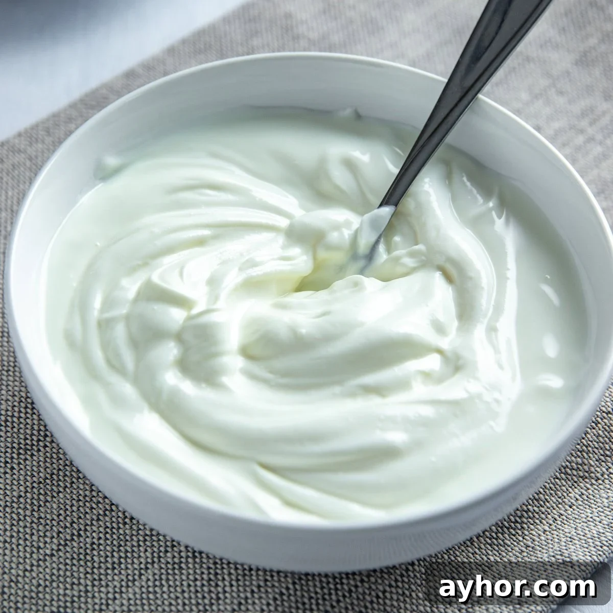 Cream Cheese Substitutes: 30+ Swaps for Any Recipe 4 Plain greek yogurt in a small white bowl with spoon inside.
