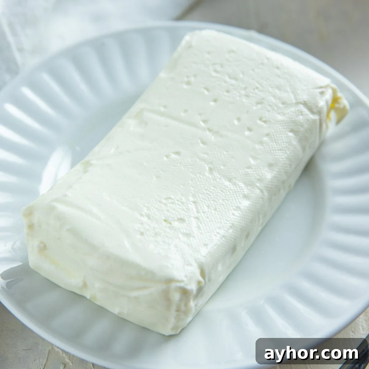 Cream Cheese Substitutes: 30+ Swaps for Any Recipe 5 A block of Neufchatel cheese on a white plate.