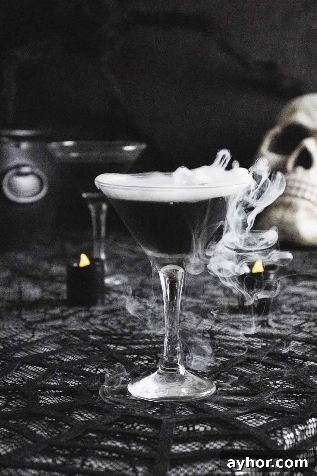 20+ Spooky Halloween Cocktail Recipes for Adults 3 Black vodka martini with smoke on dark table.