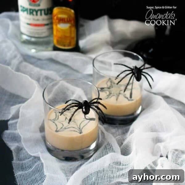 20+ Spooky Halloween Cocktail Recipes for Adults 23 Spider cocktail with spiders on cocktail glass on table.