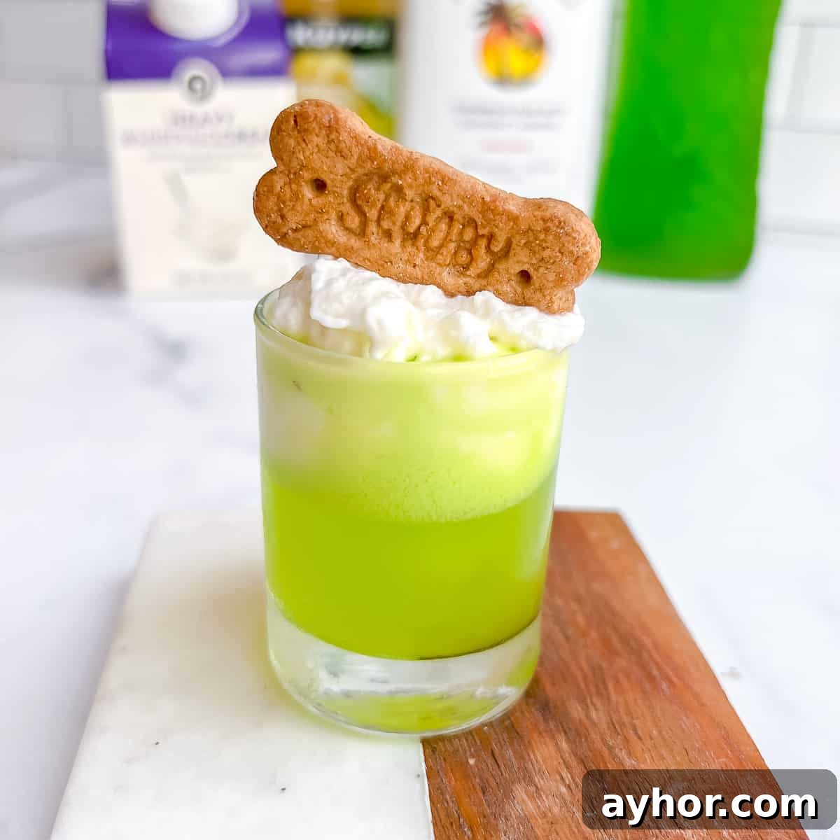 20+ Spooky Halloween Cocktail Recipes for Adults 6 Scooby snacks shot on table with scooby cookie and whipped cream.