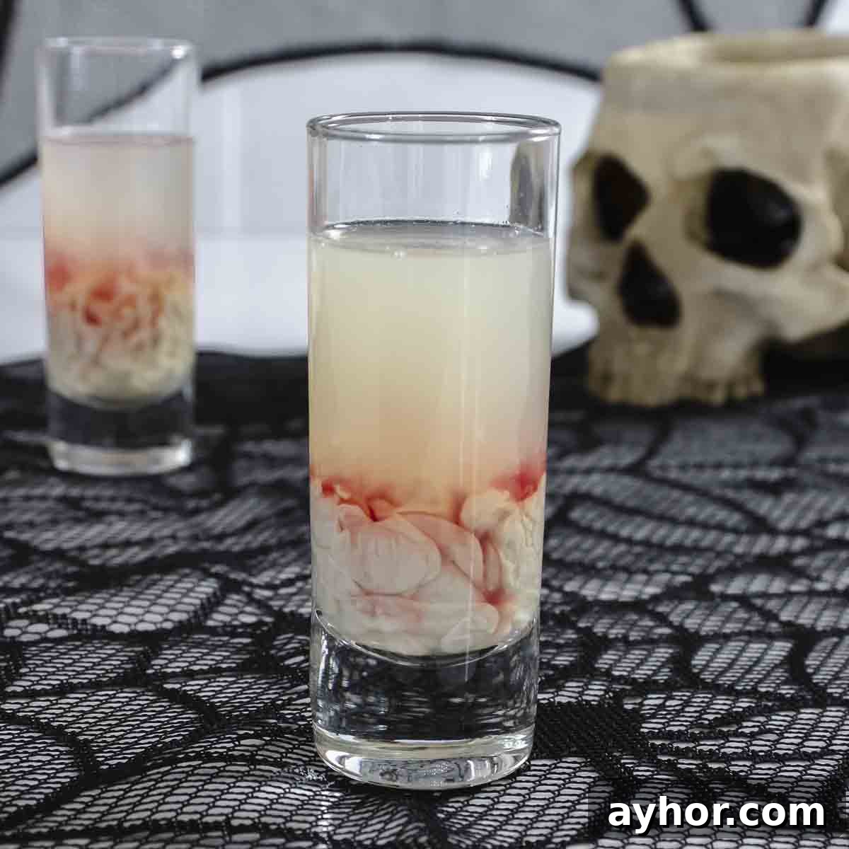20+ Spooky Halloween Cocktail Recipes for Adults 7 Monkey brain shot on table with skull.