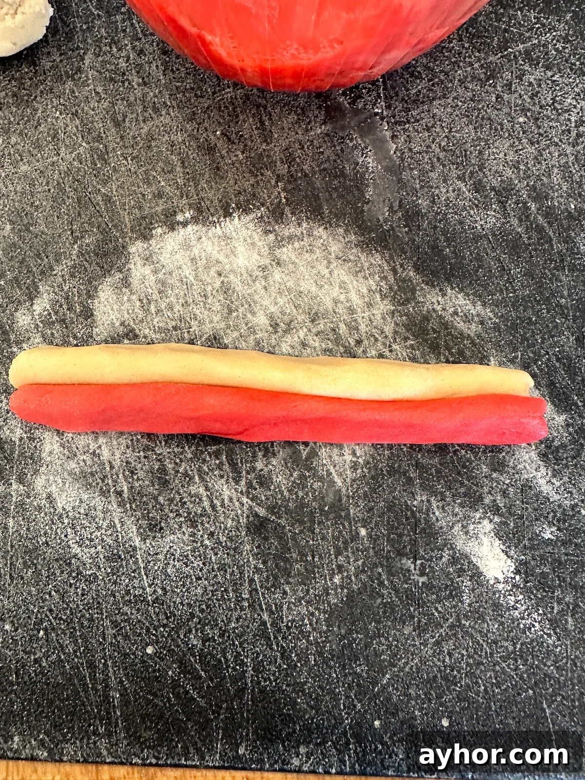 Christmas candy cane cookie strips on a cutting board.