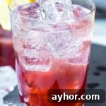 Homemade Apple Pie Moonshine Recipe – Smooth Spiced Apple Spirit 6 A glass of Sloe Gin Fizz garnished with lemon wheel