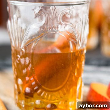 Homemade Apple Pie Moonshine Recipe – Smooth Spiced Apple Spirit 2 A glass of Apple Pie Moonshine with cinnamon stick