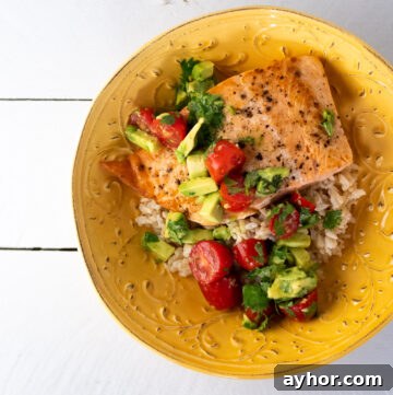 Grilled Salmon with Tomato-Caper Vinaigrette Recipe 2 Salmon with tomato avocado salsa on a bowl of rice.