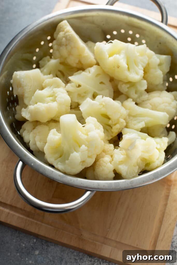 Creamy Cauliflower Gratin with Golden Cheese Crust 6 Crisp tender cooked cauliflower in a colander.
