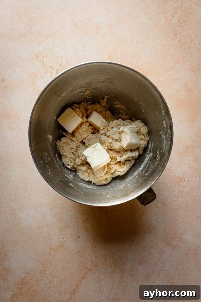 A bowl with dough and pieces of butter.